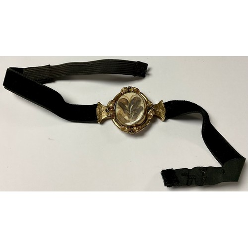 1160 - A Victorian mourning choker, the gold plated oval swivel centrepiece applied with an arrangement of ... 