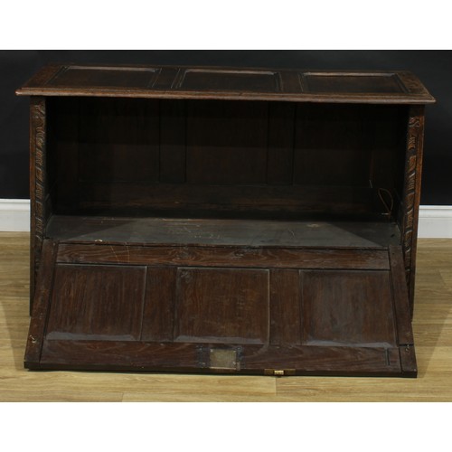 402 - A late 17th century style oak fall front blanket chest, the front carved throughout with stylised fl... 