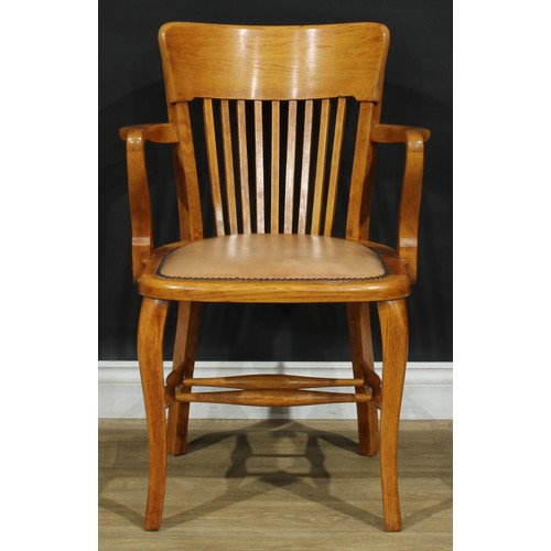 407 - A set of four early to mid 20th century oak elbow chairs, each with a curved cresting rail, stuffed-... 