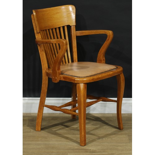 407 - A set of four early to mid 20th century oak elbow chairs, each with a curved cresting rail, stuffed-... 