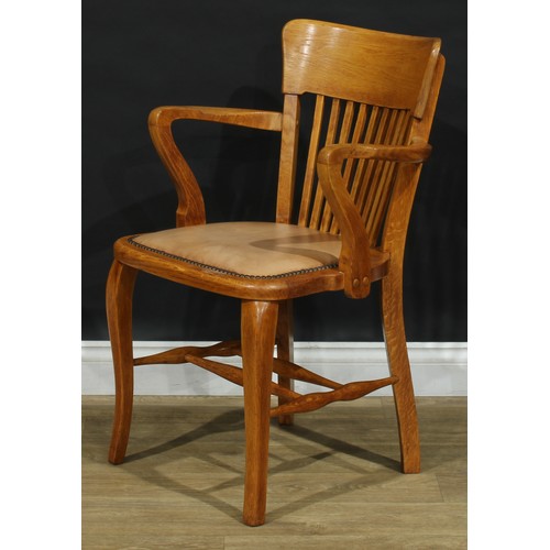 407 - A set of four early to mid 20th century oak elbow chairs, each with a curved cresting rail, stuffed-... 