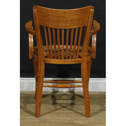 407 - A set of four early to mid 20th century oak elbow chairs, each with a curved cresting rail, stuffed-... 