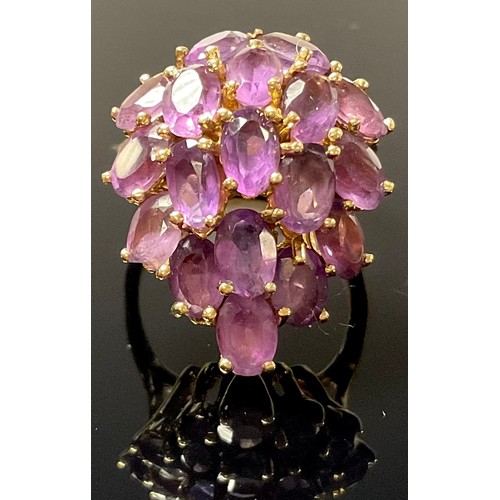 1206 - A gold coloured metal and amethyst dress ring, the 18 oval cut stones claw set