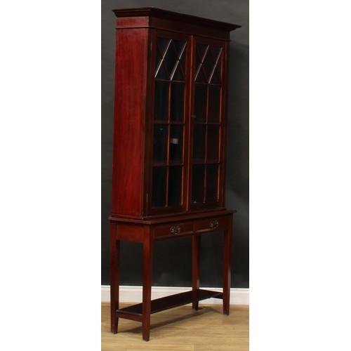 818 - A George III style mahogany bookcase on stand, outswept cornice above a pair of glazed doors, the ba... 