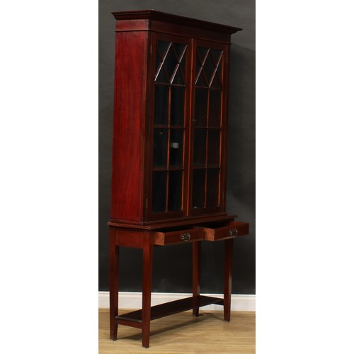 818 - A George III style mahogany bookcase on stand, outswept cornice above a pair of glazed doors, the ba... 