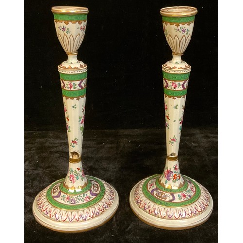 395A - A pair of 18th century Chinese Export table candlesticks, painted in the Famille Verte palette, face... 