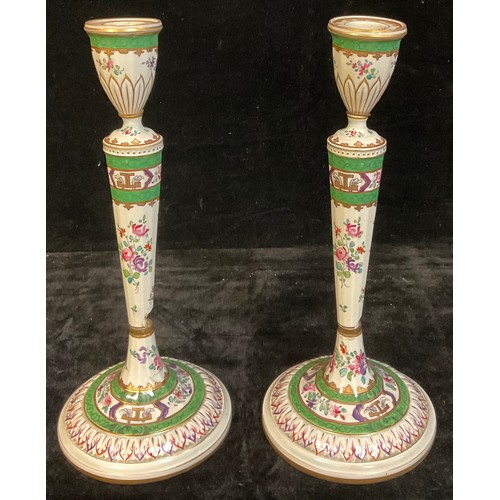 395A - A pair of 18th century Chinese Export table candlesticks, painted in the Famille Verte palette, face... 