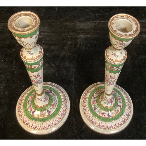 395A - A pair of 18th century Chinese Export table candlesticks, painted in the Famille Verte palette, face... 