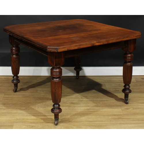 105A - A late Victorian/Edwardian extending dining table, chamfered rectangular top with one additional lea... 