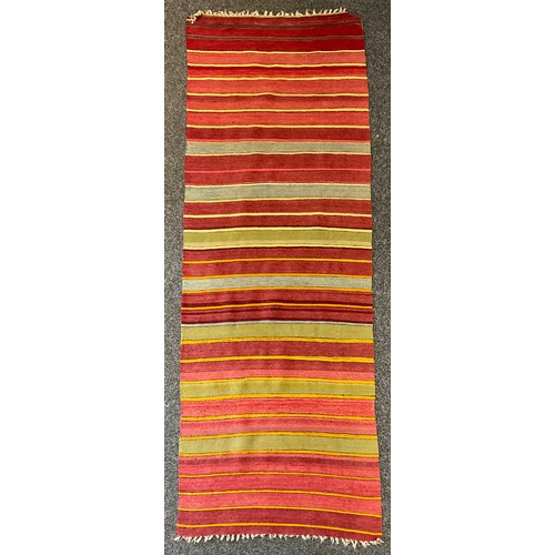 1285 - A Turkish woollen rug/runner, in bands of red, orange, ochre, black and green, 76cm wide, 208cm long