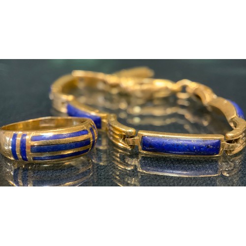 439 - A Middle eastern/Egyptian lapis lazuli inset gold coloured metal bracelet, indistinctly marked,  cat... 