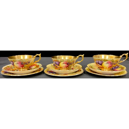 43 - A set of three Aynsley Orchard Gold pattern teacups, saucers and tea plates printed with ripe fruits... 