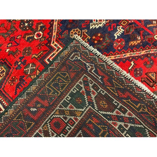 255 - A South West Persian Shiraz carpet / rug, hand-knotted with triple diamond medallions within a field... 