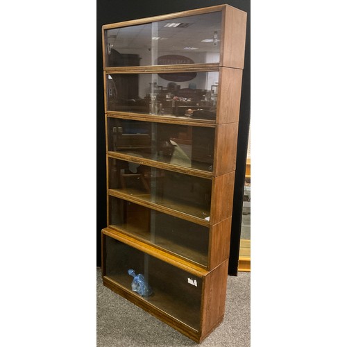 256 - A Minty style oak stackable bookcase, six tiers, shading glass doors, 186cm high x 91cm wide x 27cm ... 