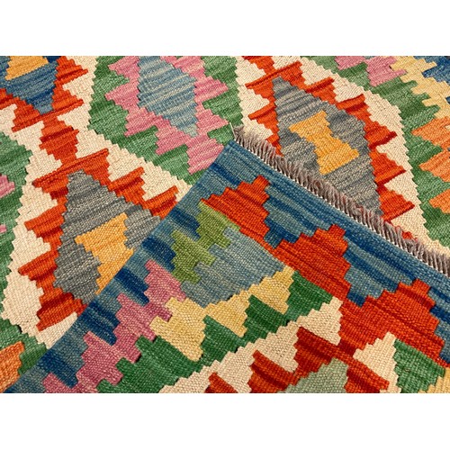 282 - A Turkish Anatolian Kilim runner carpet / rug, woven in tones of blue, green, red, and cream, 290cm ... 