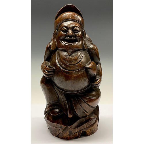 3075 - A Chinese bamboo figure, carved as a rotund Buddhist monk holding a fish, 28cm high