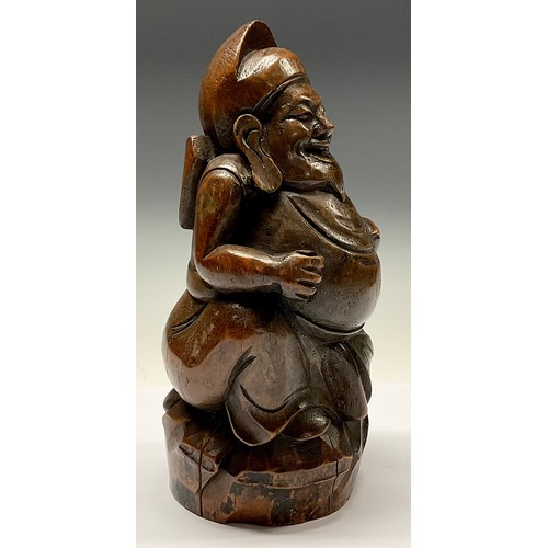 3075 - A Chinese bamboo figure, carved as a rotund Buddhist monk holding a fish, 28cm high