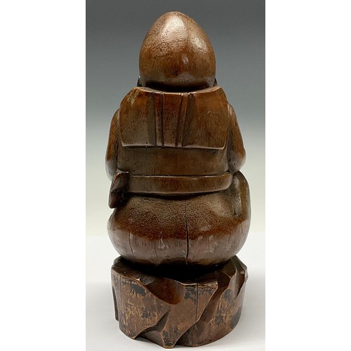 3075 - A Chinese bamboo figure, carved as a rotund Buddhist monk holding a fish, 28cm high