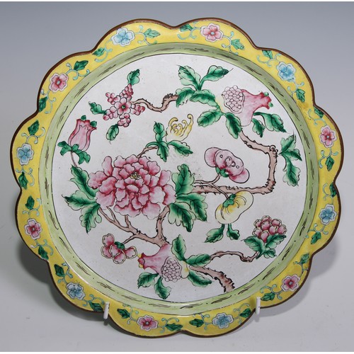 3070 - A Cantonese enamel shaped circular plate, painted in the famille rose palette with flowering branche... 