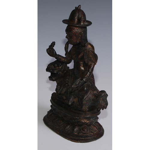 3664 - Tibetan School, a red and gilt patinated bronze, Vajrasadhu seated on a lion, lotus base, 28cm high