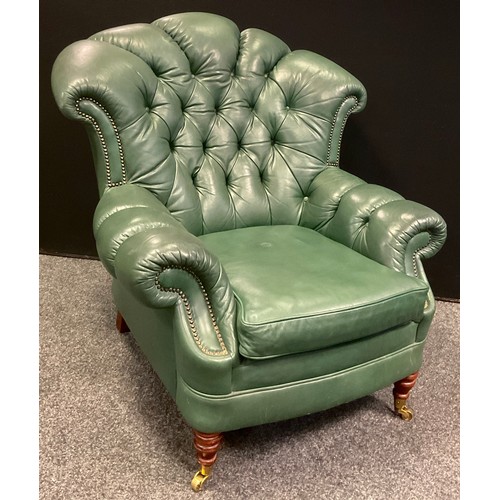 339 - A pair of Chesterfield deep button back armchairs, fan-shaped backs, green leather, turned legs, bra... 