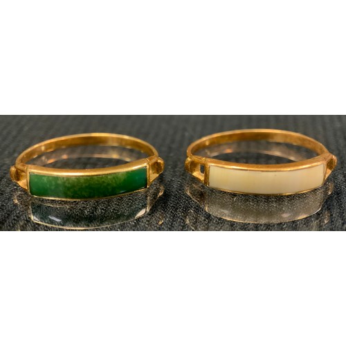 422 - A green stone channel set dress ring possibly jade, yellow metal shank, stamped 750, size M/N;  anot... 