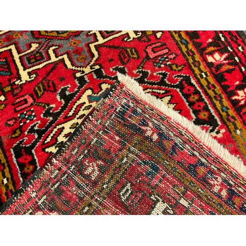 33 - A North West Persian Heriz runner, hand-knotted in tones of red, black, blue, and cream, 275cm x 75c... 