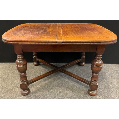 61 - A mid 20th century oak extending dining table, rounded rectangular top, turned legs, X-frame stretch... 