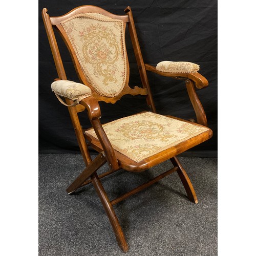 69 - A late Victorian mahogany folding campaign chair, shield-shaped back, upholstered back, arms, and se... 