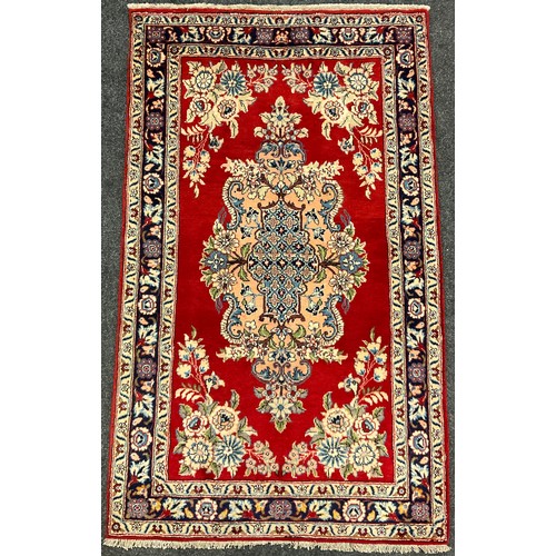 73 - A Central Persian Qum rug / carpet, ornate medallion within a rich red field, stylised floral margin... 