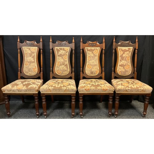 79 - A set of four Art Nouveau walnut dining chairs, turned finials, upholstered shield-shaped backs, and... 