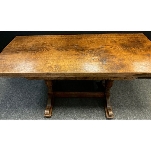 82 - A 20th century Arts and crafts style oak trestle table, solid quarter-sawn oak top, turned supports,... 