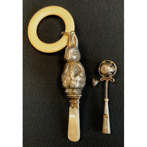 442 - A silver, mother of pearl and ivorine teething ring and rattle as Peter Rabbit; another (2)