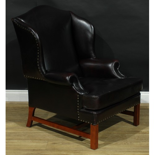 112 - A pair of contemporary George III style wing armchairs, by Parker Knoll, stuffed-over aubergine leat... 