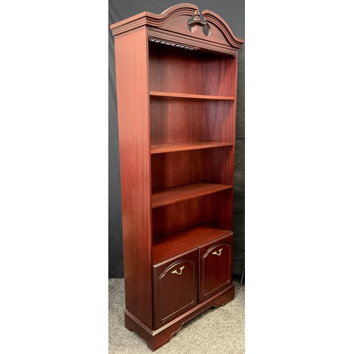 37 - A reproduction mahogany veneered tall bookcase, swan-neck pediment, three tiers of shelving, small c... 