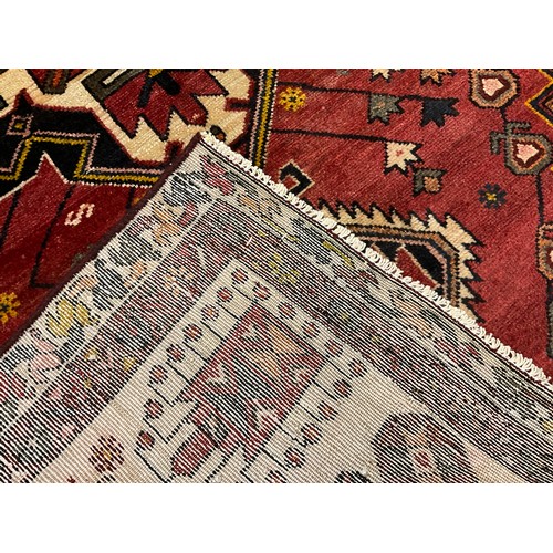 220 - A North west Persian Heriz rug / carpet, hand-knotted in tones of red, deep blue, brown and cream, 1... 