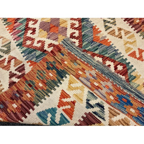 227 - A Turkish Anatolian Kilim rug / carpet, knotted in bright tones of red, orange, green, and cream, 15... 