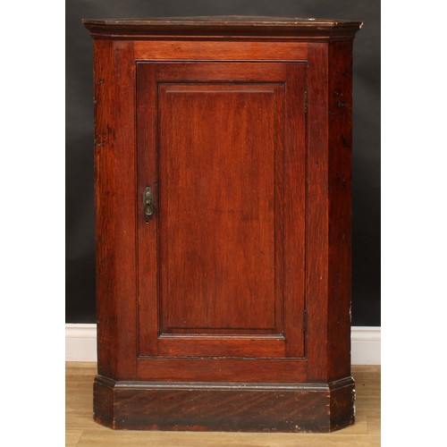 228 - A 19th century mahogany splay front corner cabinet, moulded cornice above a pair of panel doors, enc... 