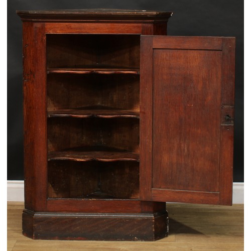 228 - A 19th century mahogany splay front corner cabinet, moulded cornice above a pair of panel doors, enc... 