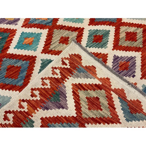 230 - A Turkish Anatolian Kilim rug / carpet, knotted in vibrant tones of red, jade green, orange, and blu... 