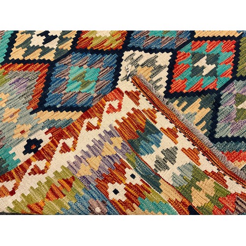 232 - A Turkish Anatolian Kilim rug / carpet, knotted in vibrant tones of red, turquoise, indigo, and gree... 