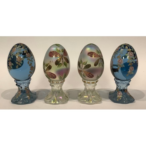 A pair of American Fenton glass hand painted opalescent eggs on stands