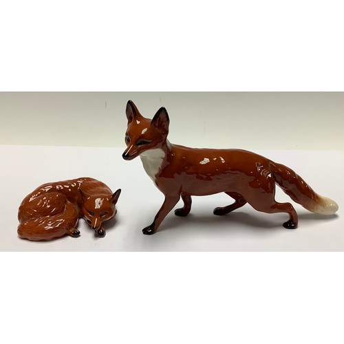 167 - A Beswick model of a fox curled sleeping, printed mark, green sticker, 10cm wide; another walking fo... 