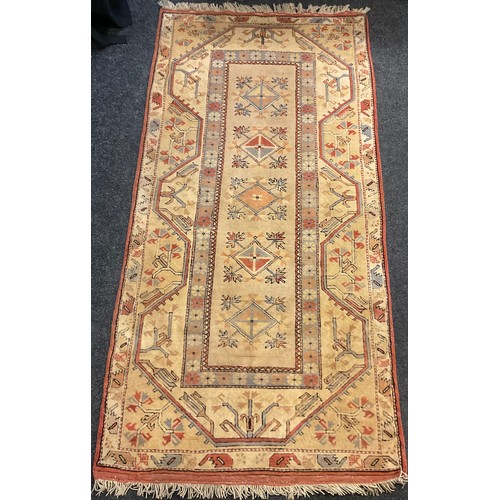 87 - A woollen carpet with floral design; two others similar, smaller; a woollen rug with geometric desig... 