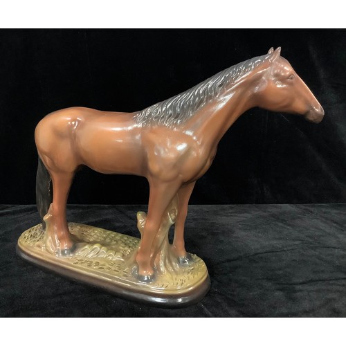 24 - A Staffordshire model of a bay horse, 37cm high, 48cm wide