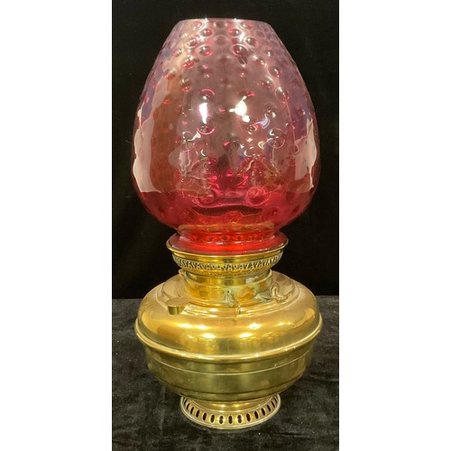 61 - A large brass Veritas oil lamp, cranberry glass shade, 48cm high