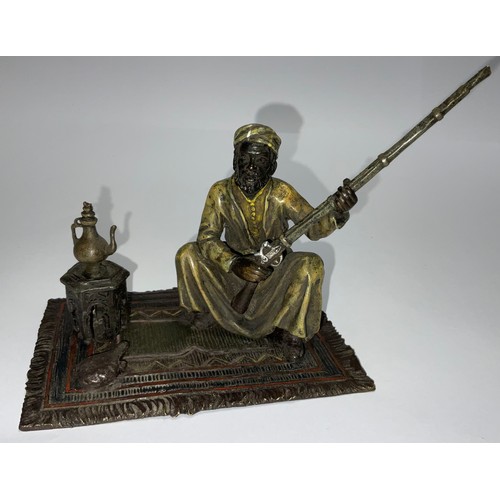 85 - A Viennese cold painted bronze, of an Arab seated on carpet holding a rifle, 12cm high