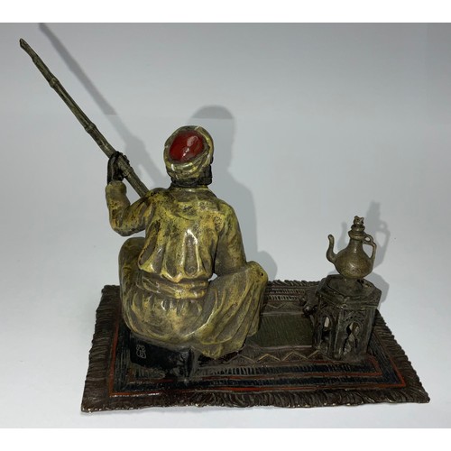 85 - A Viennese cold painted bronze, of an Arab seated on carpet holding a rifle, 12cm high