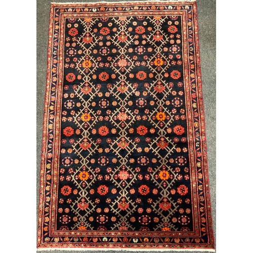 69 - A North west Persian Hamadan rug / carpet, hand-knotted with stylised flowers in tones of red, orang... 