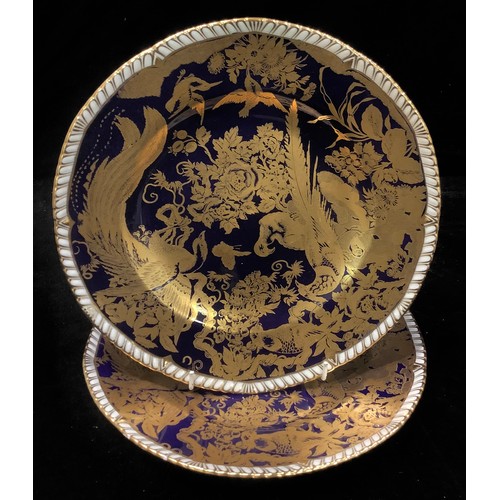 154 - A pair of Royal Crown Derby Gold Aves pattern shaped circular dinner plates, on a cobalt blue ground... 